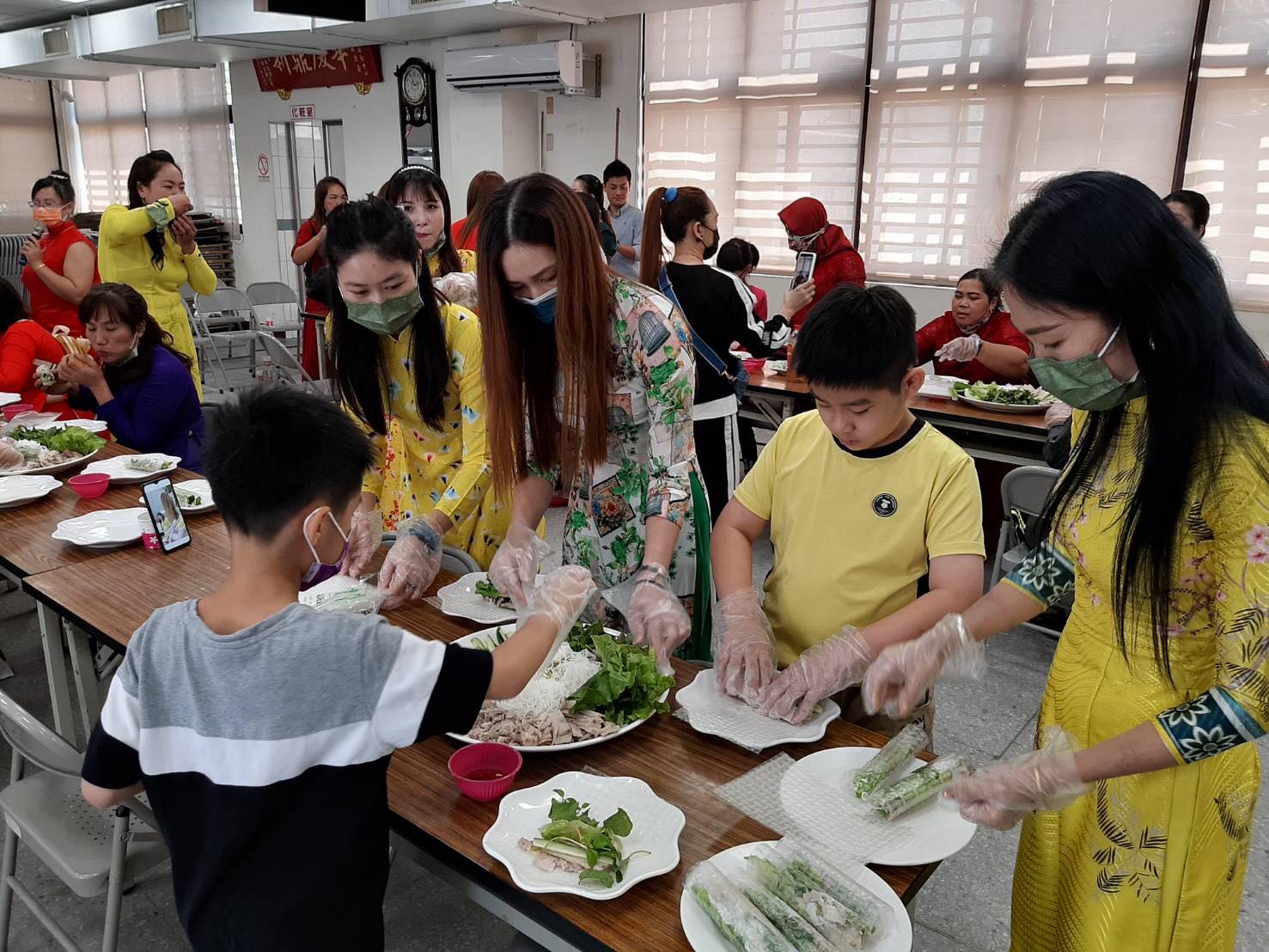 Gia đình các di dân mới cùng các con tự tay làm món gỏi cuốn Việt Nam. (Nguồn ảnh: Trạm Phục vụ số hai của Sở Di dân tại thành phố Đài Nam)