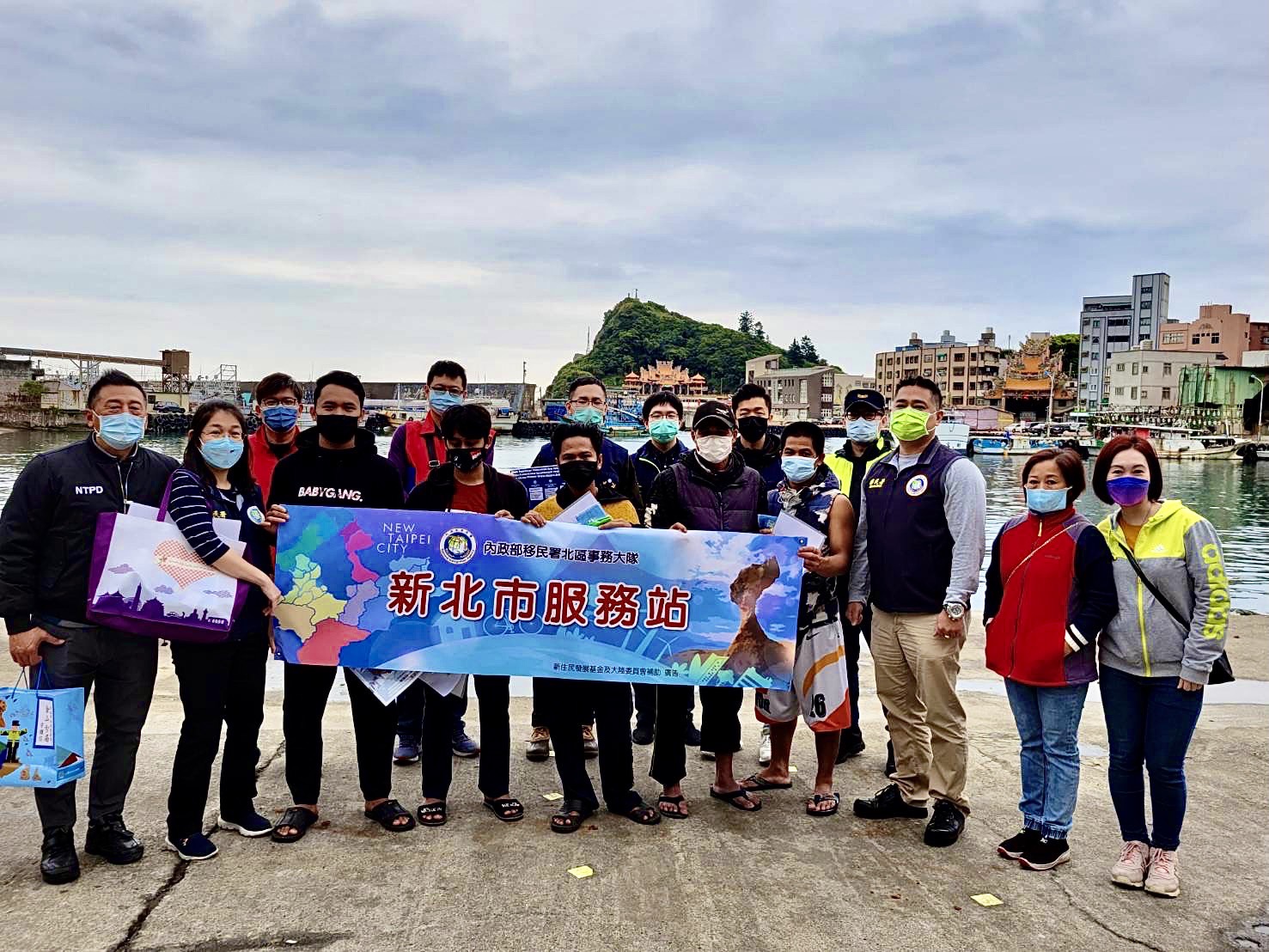 Kantor Imigrasi Kota New Taipei dan Kantor Polisi Jinshan berfoto bersama dengan para nelayan asing di area pelabuhan yang menerima pengumuman pencegahan pandemi. Sumber: Stasiun Layanan Kota New Taipei