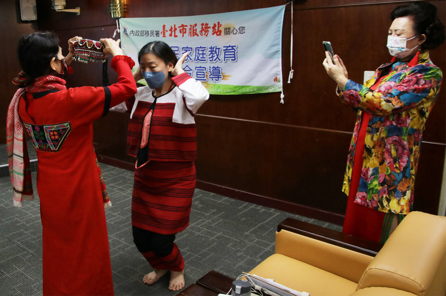 新住民姊妹體驗原住民賽德克族傳統服飾，爭相拍照記錄。（圖／臺北市服務站提供）