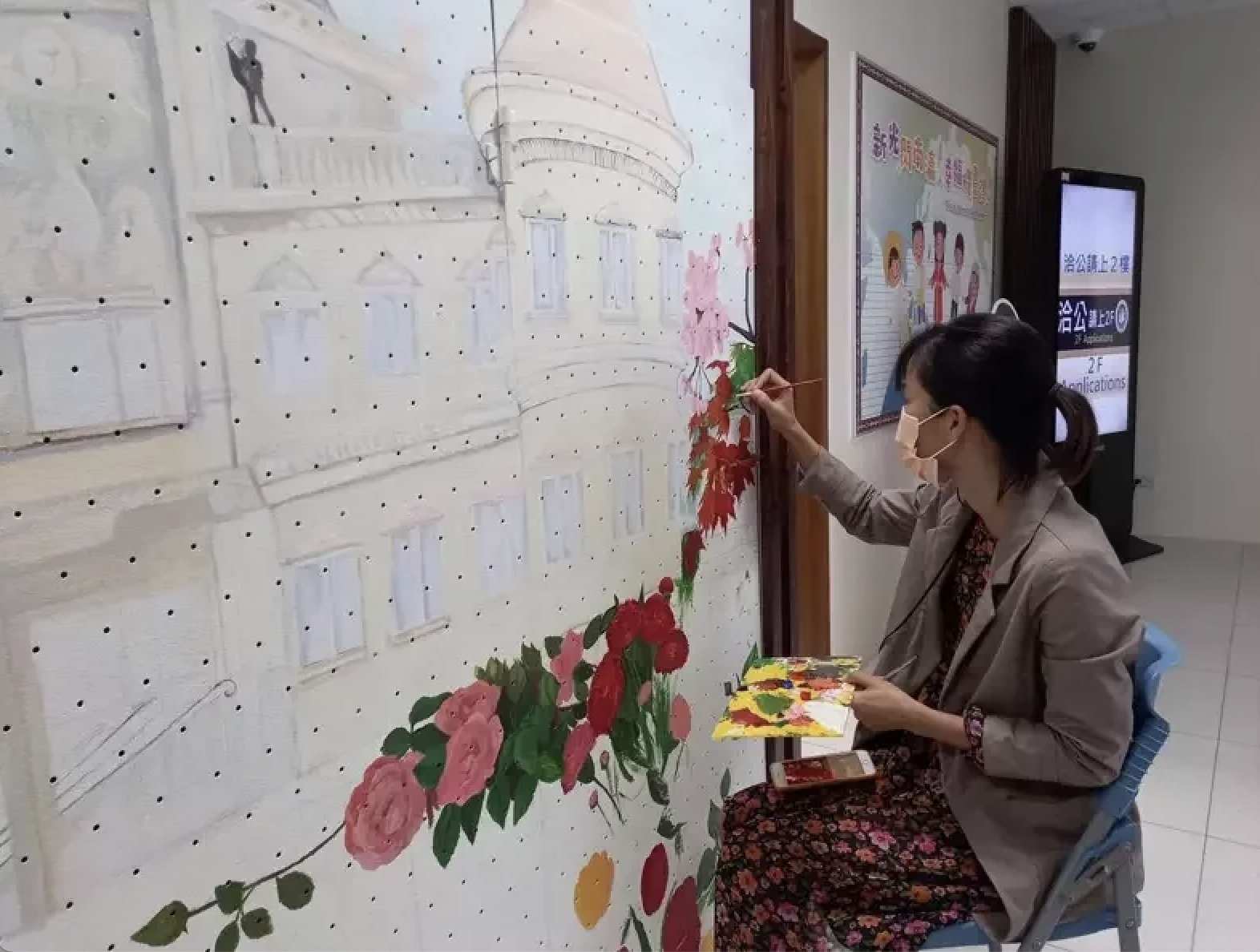 高冰雪在移民署台南第一服務站入口處創作出美麗的壁畫。（圖／移民署提供）