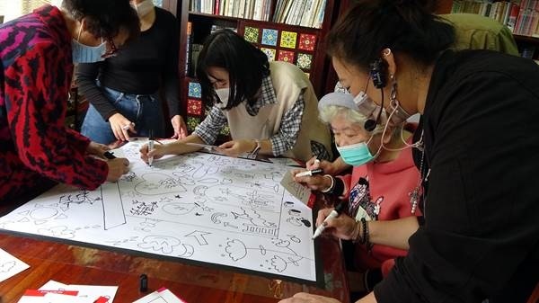 Du học sinh Việt Nam và các cụ bà cùng hoàn thành các tác phẩm hội họa. (Nguồn ảnh: Đại học Khoa học kỹ thuật Đài Loan)