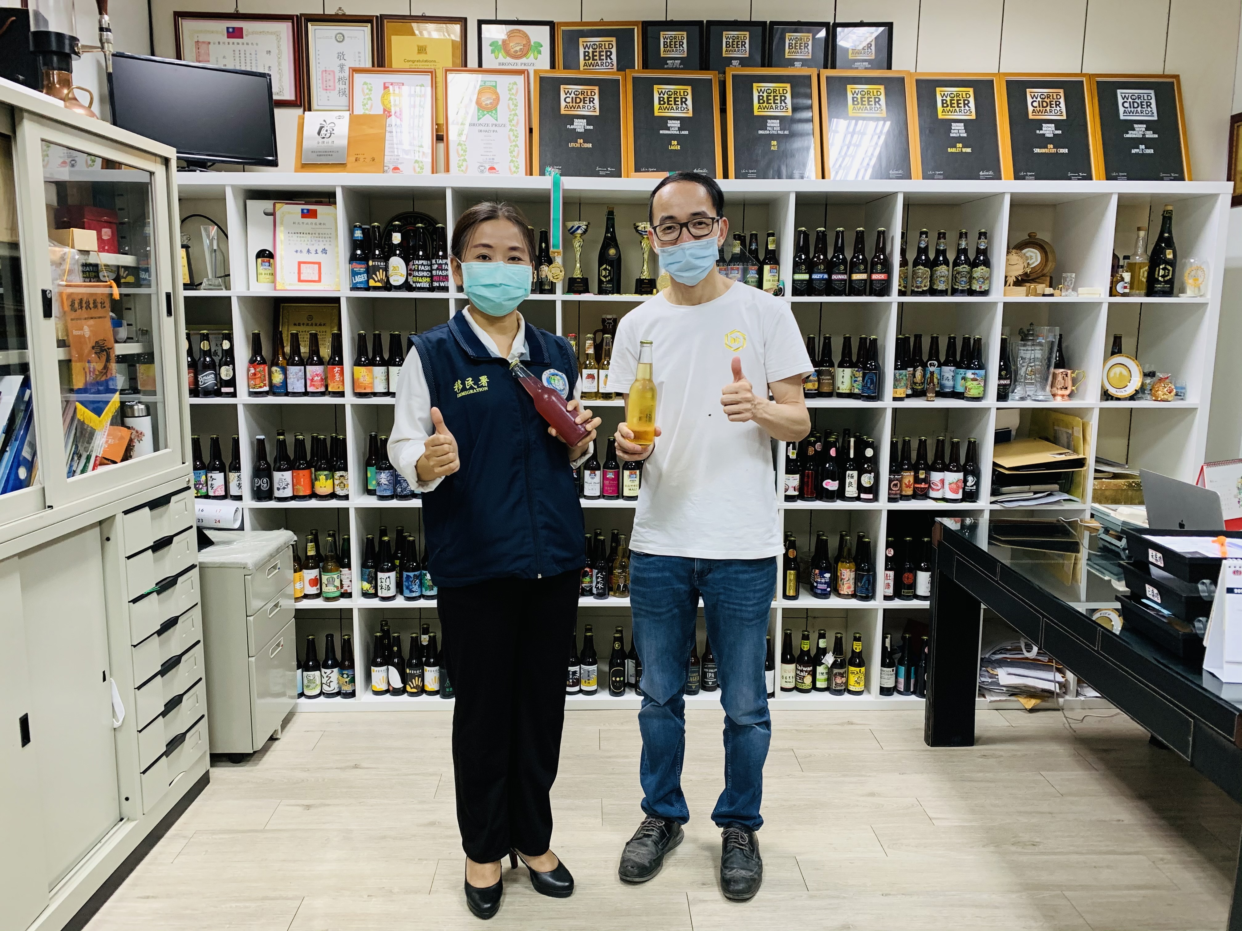 鄧淑達先生(右)向服務站主任黃英貴(左)分享釀造的水果酒。（圖／桃園市服務站提供）