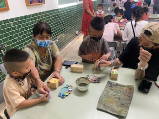 Orang tua dan anak-anak berpartisipasi dalam kegiatan lukisan santo pelindung Kinmen "Shisa" di kotak penaruhan pena. Sumber: Diambil dari Stasiun Layanan Kabupaten Kinmen
