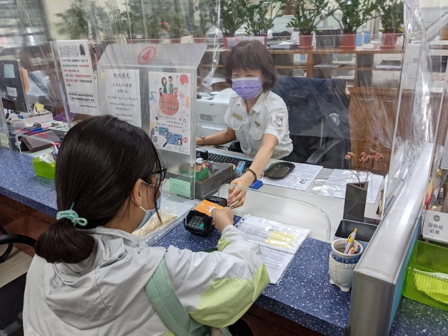 Penjelasan: Warga yang sedang melakukan transaksi pembayaran dengan menggunakan alat pendeteksi kartu. Sumber: Kantor Layanan Imigrasi Cabang Pertama Kota Taichung