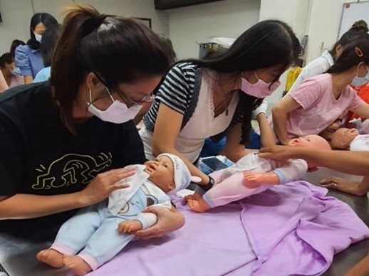 Di dân mới người Việt học cách chăm sóc trẻ sơ sinh. (Nguồn ảnh: Văn phòng Lao động huyện Chương Hóa)