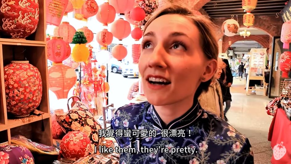 Youtuber Canada Kelsi mặc sườn xám đi chợ Xuân, trải nghiệm văn hoá truyền thống. (Nguồn ảnh: kênh YouTube “Kelsi May凱西莓”)