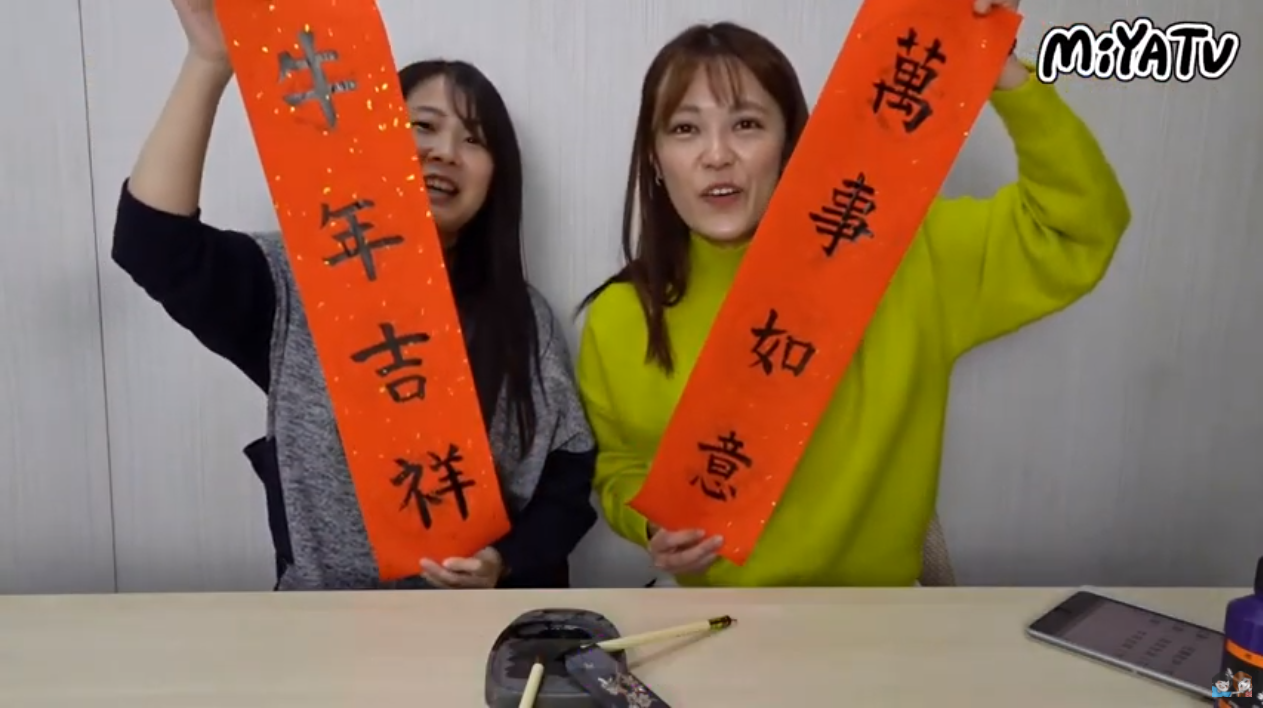 Aya(bên trái) và Mion (bên phải) cùng viết câu đối (Nguồn ảnh: MiYA TV cung cấp)