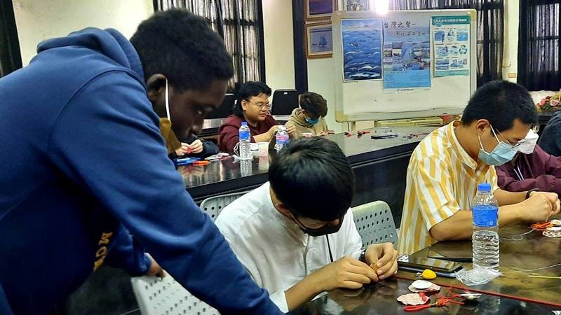 外籍大學生與社區阿嬤學做「文蛤香包」。 圖／明道大學提供