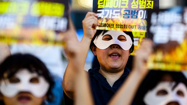 Activists wearing eye masks hold posters reading 'Repeated deepfake sex crimes, the state is an accomplice too' during a protest against deepfake porn in Seoul, South Korea on August 30, 2024. Anthony Wallace/AFP/Getty Images/File