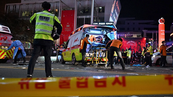 Medical staff attend to a person on a stretcher in the popular nightlife district of Itaewon in Seoul on October 30, 2022, after thousands of people crowded into the neighborhood's narrow streets to celebrate Halloween.  Jung Yeon-Je/AFP/Getty Images