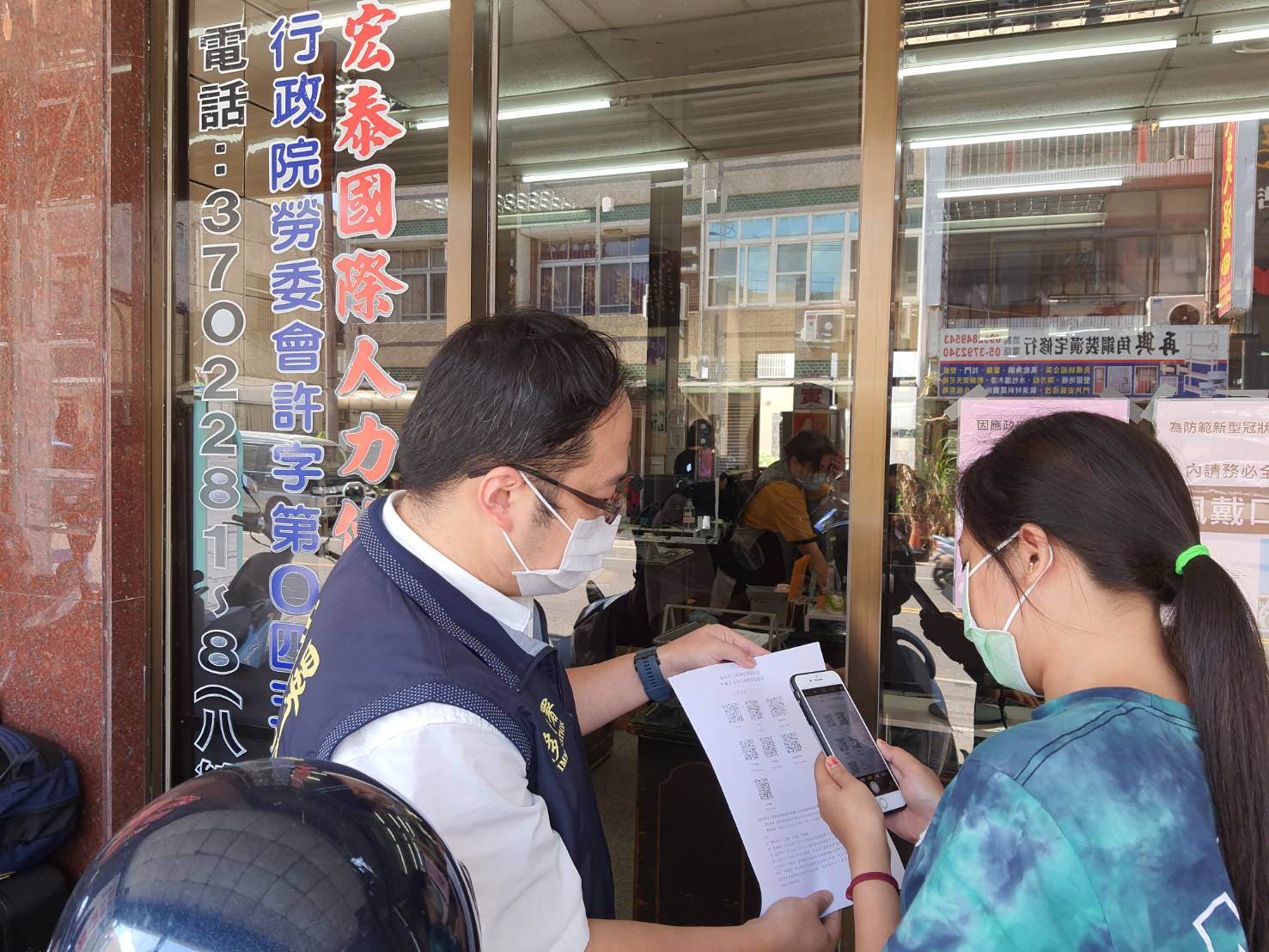 The staff of the NIA Chiayi County Service Station guides new immigrant friends to scan QR-codes when entering venues and automatic residence extensions. (Photo / Provided by the Chiayi County Service Station)