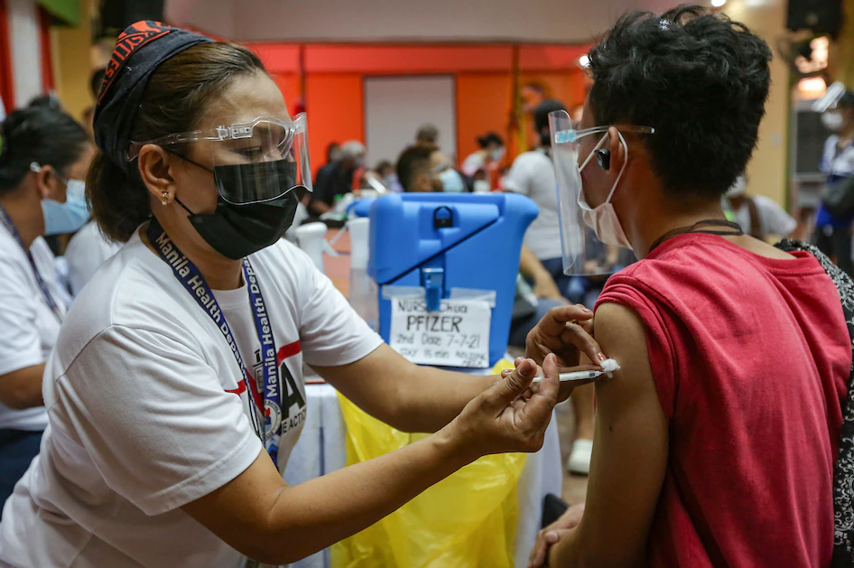 Health workers inoculate residents with the Pfizer COVID-19 vaccine inside the Corazon Aquino Highschool in Baseco Compound in Tondo, Manila on June 16, 2021. (Photo courtesy of George Calvelo, ABS-CBN News)