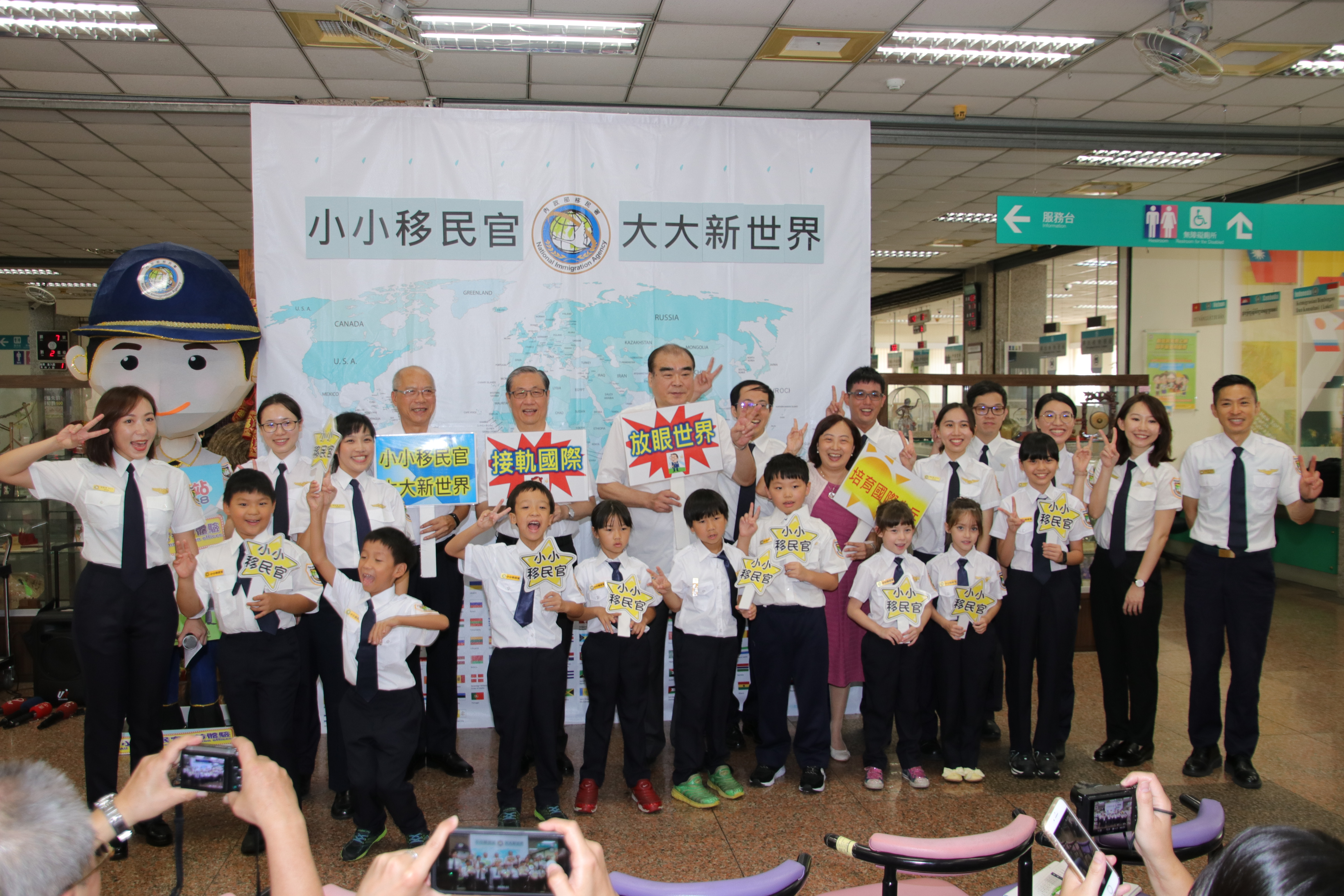 The head of NIA, Chiu Feng-kuang (邱豐光), the officers, and children took picture together 