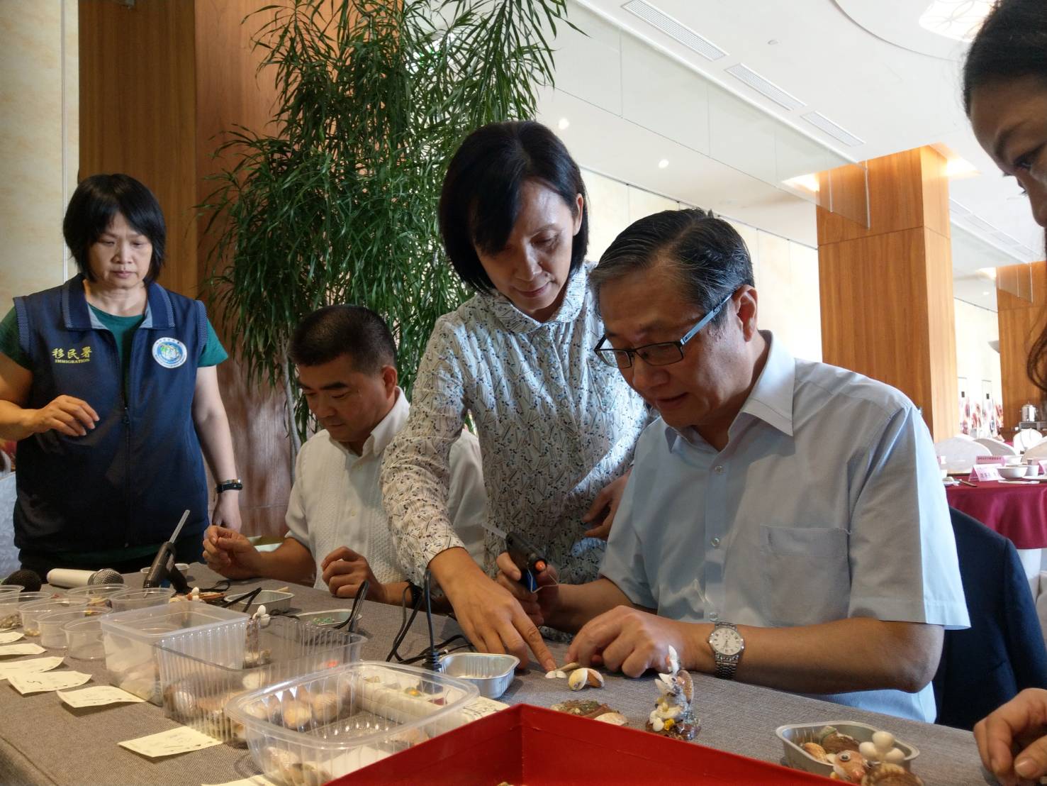 Wakil Direktur Zhong berpartisipasi dalam pendidikan keluarga multikultural di stasiun layanan di Kabupaten Penghu , yang mengkhususkan diri dalam kegiatan kerajinan kerang dan kerang.Dosen Xu Jianfeng memimpin produksi kerajinan kerang. Sumber Gambar Departemen Imigrasi