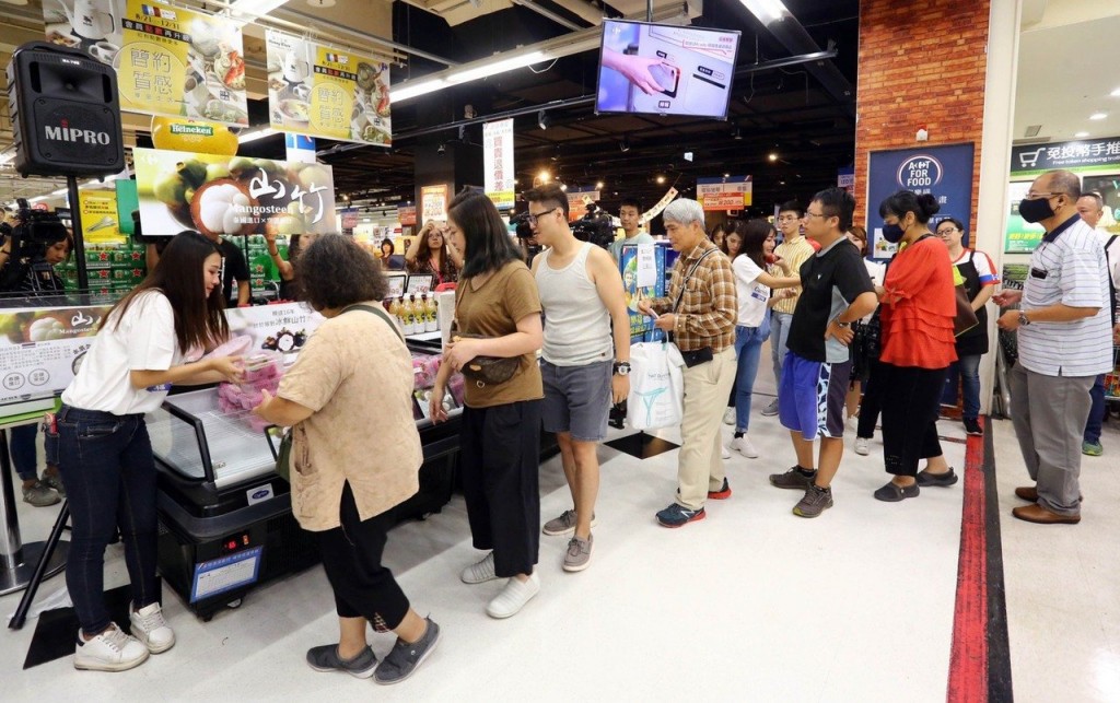 Employee hands out mangosteens to customers. (Carrefour photo)