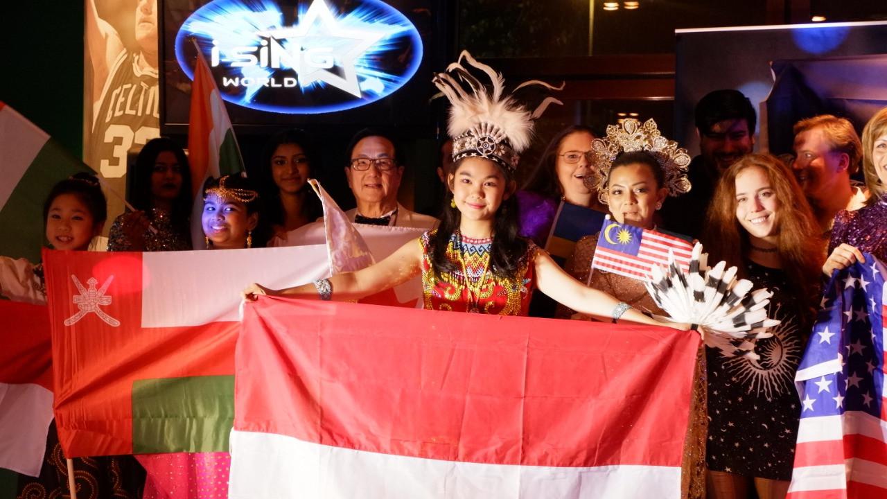 Juara 1 kategori junior pada I-Sing World 2019, Maria Sinaga mengenakan pakaian adat sembari memegang bendera Indonesia di Stockholm, Swedia 