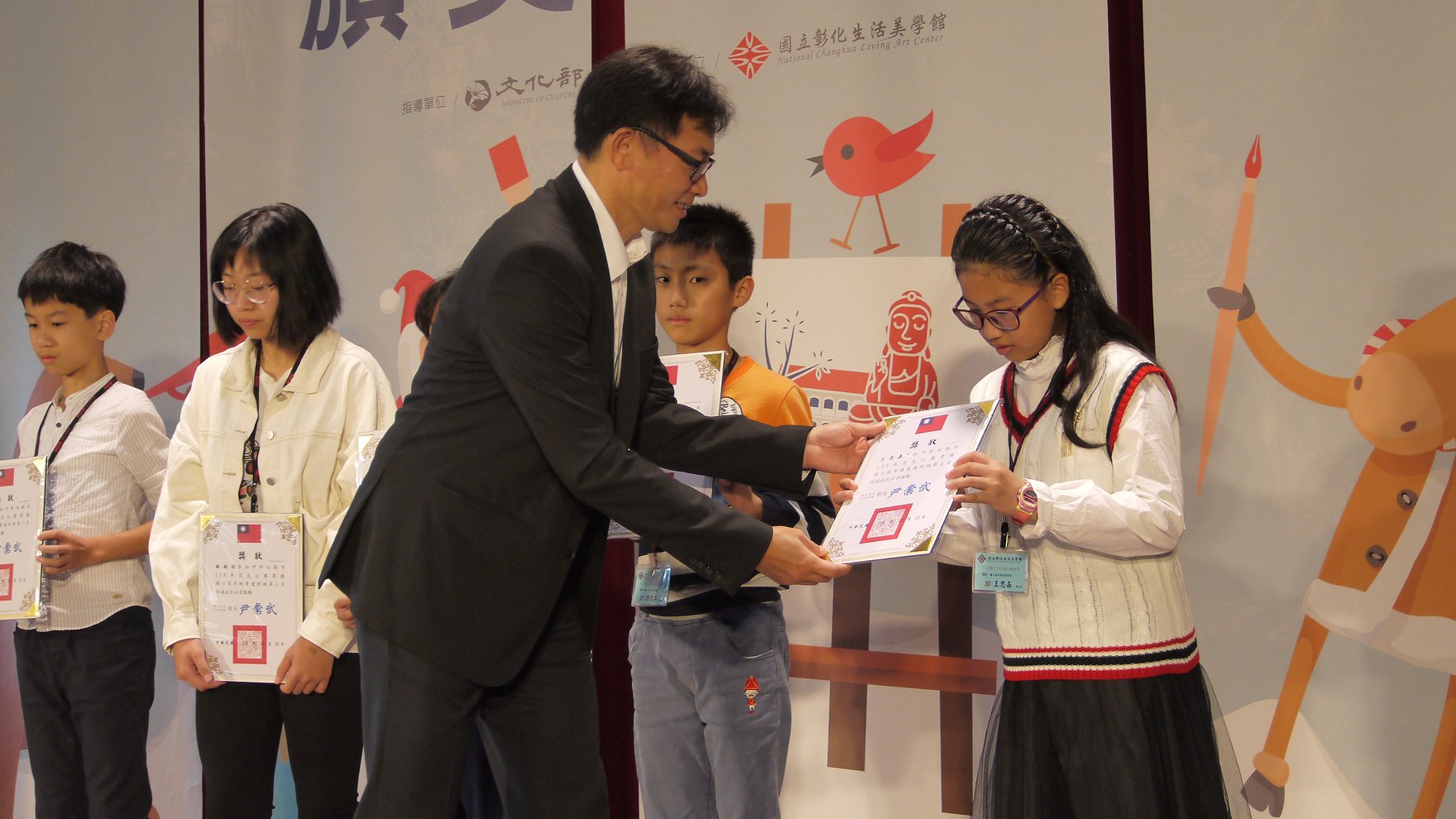 A new resident kid, Wang Sijia, is awarded for her outstanding drawing. Photograph: Ministry of Culture.