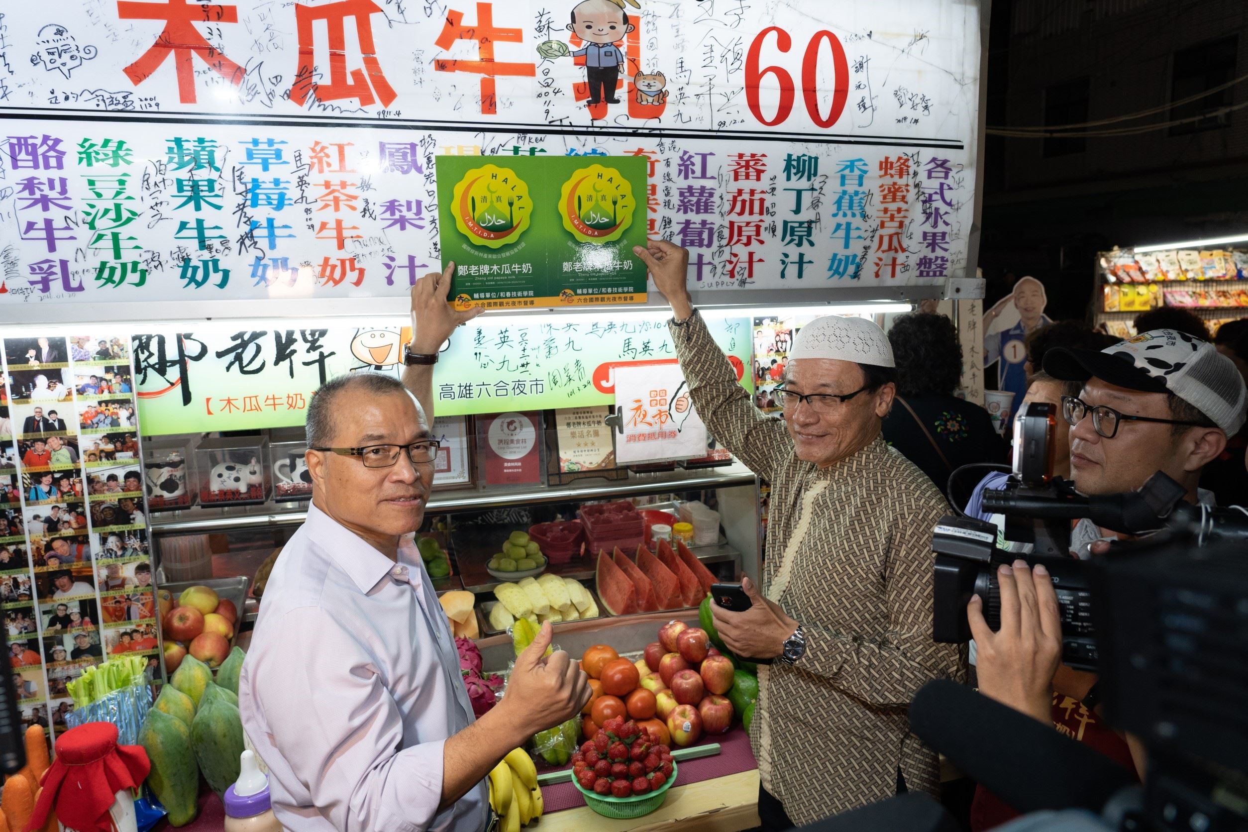 Explanation: the acting mayor, Ye Kuangshi, assists in putting up the plate of Halal certification for a vendor. Photograph: Kaohsiung City Government