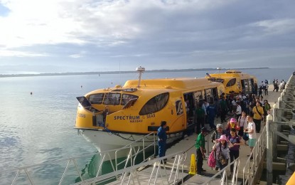 Cruise passengers alight from a boat at the Ilocos port while tour guides welcome them with leis. Photograph: PNA.