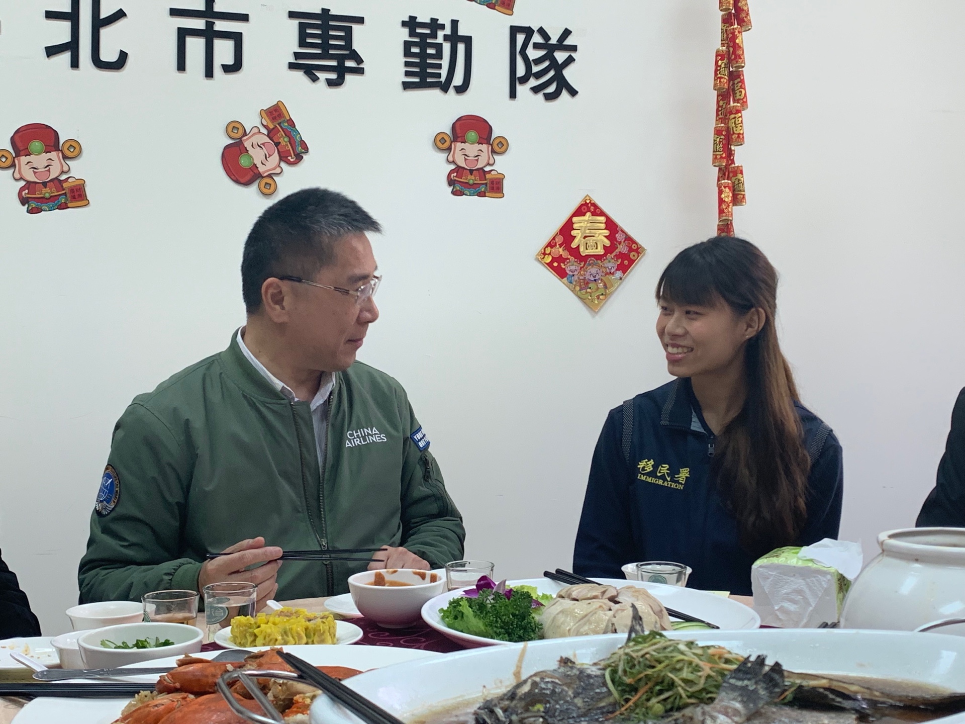 徐部長專心聆聽台北市專勤隊抬拳道3段科員花羽庭（右）分享查緝失聯移工的小故事(移民署提供)