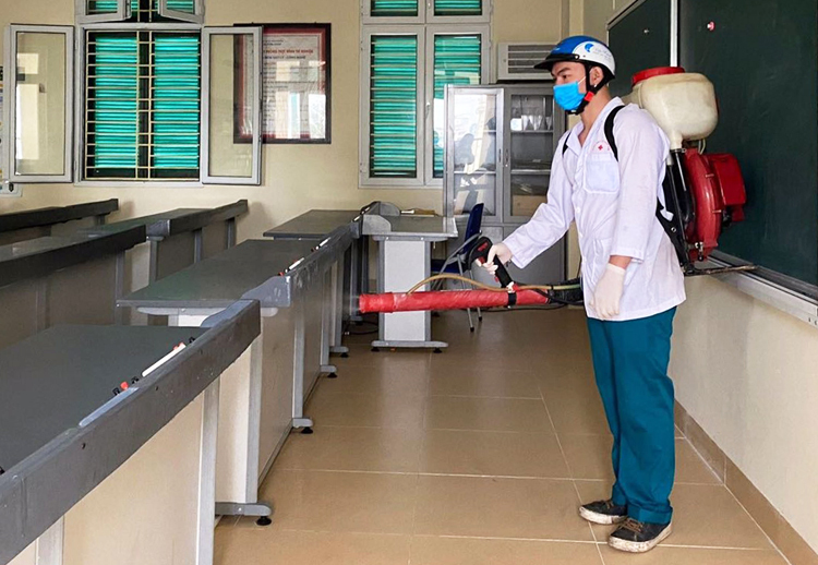 Nhân viên y tế phun thuốc khử trùng ở trường THCS Trưng Vương, quận Hoàn Kiếm, Hà Nội