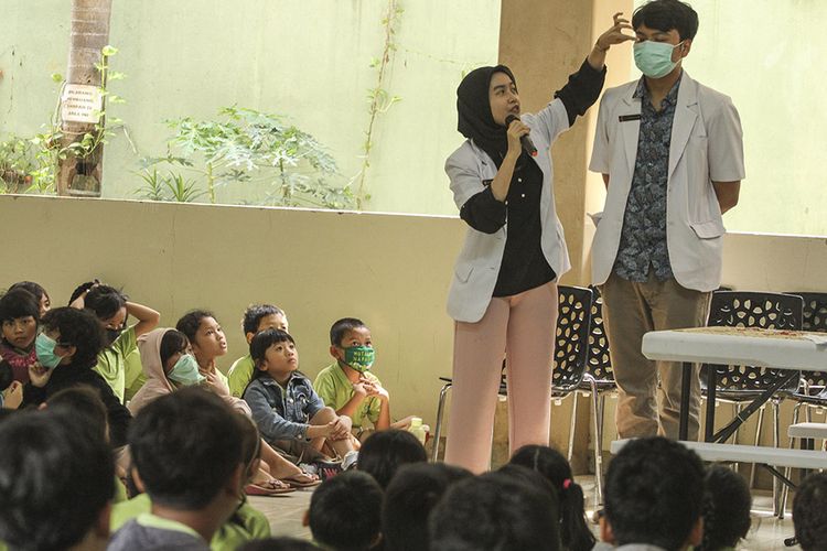 Petugas Puskesmas mempraktikan penggunaan masker kepada sejumlah siswa saat sosialisasi di Sekolah Tunas Global, Depok, Jawa Barat