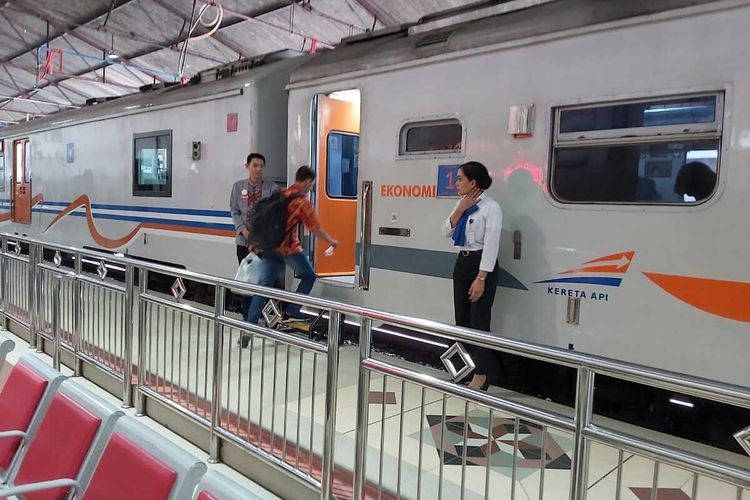 Penumpang naik kereta api di Stasiun Madiun meski terlambat lantaran terkena dampak banjir, Rabu