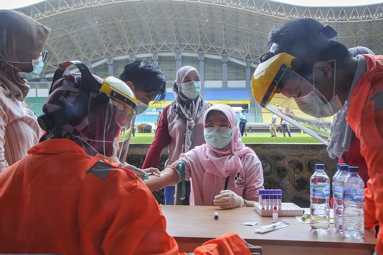 Petugas medis mengecek kesehatannya dengan mengambil sampel darah dengan metode rapid test (pemeriksaan cepat) di Stadion Patriot Candrabhaga, Bekasi, Jawa Barat, Rabu.