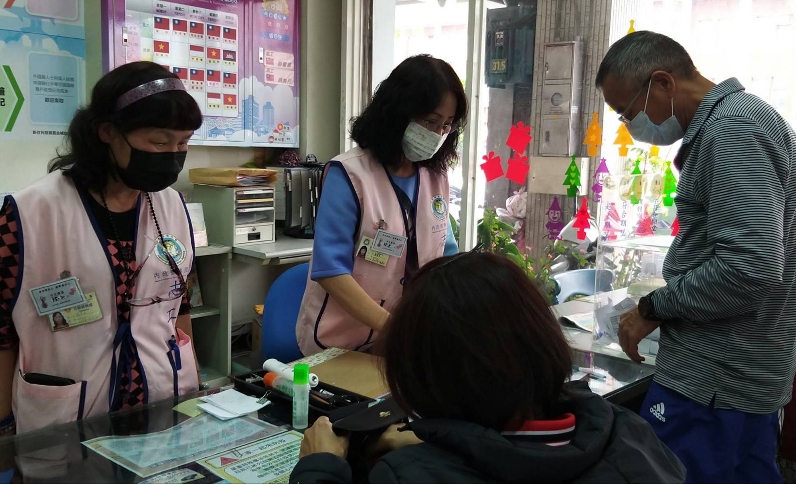 Nhân viên phục vụ tại quầy/ nhân viên tình nguyện/ phiên dịch đều đeo「Thẻ thân nhiệt」(ảnh Bộ Nội chính)