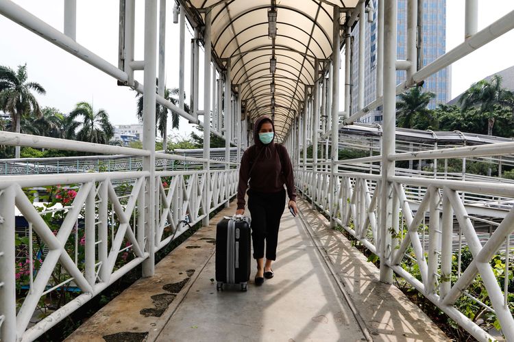 Warga melintas di jembatan penyeberangan orang (JPO) di Jalan MH Thamrin, Jakarta Pusat pada akhir pekan, Sabtu (18/4/2020)