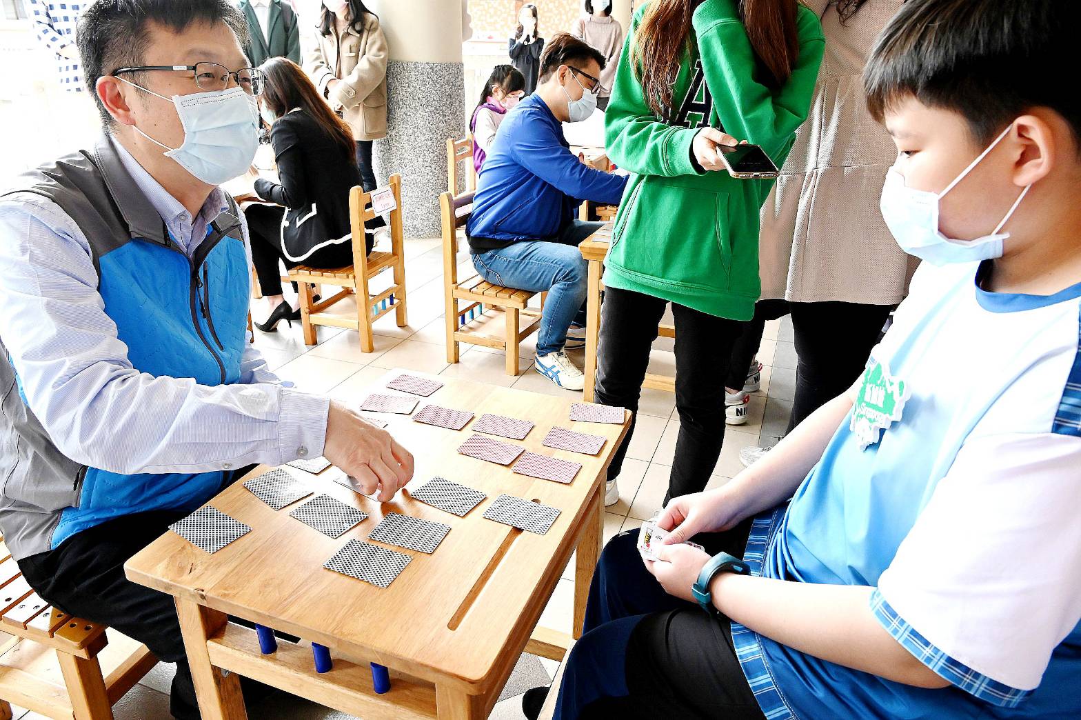 Direktur Pendidikan Pemerintah Kota Xinbei Zhang Mingwen juga bermain kartu dengan siswa dan belajar simbol fonetik melalui permainan. (Sumber foto: Biro Pendidikan Kota Xinbei)