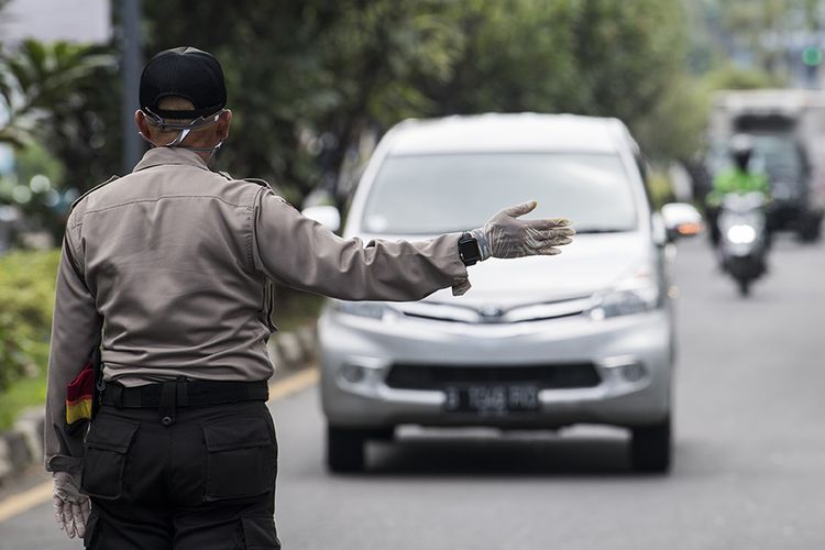 Polisi mengarahkan kendaraan roda empat untuk menjalani pemeriksaan saat penerapan pembatasan sosial berskala besar (PSBB) di Pasteur, Bandung,
