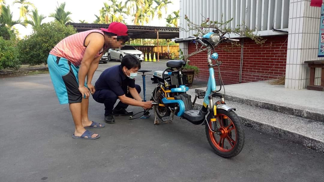 Petugas Kantor Polisi Cabang Pingtung, Zheng Chaoyou membantu para pekerja untuk mengisi kembali ban. (Sumber foto: Kantor Polisi Kabupaten Pingtung)