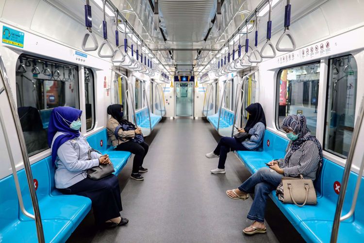 Penumpang dengan berjaga jarak duduk di kereta MRT tujuan Bundaran HI, Jakarta Pusat(Kompas)