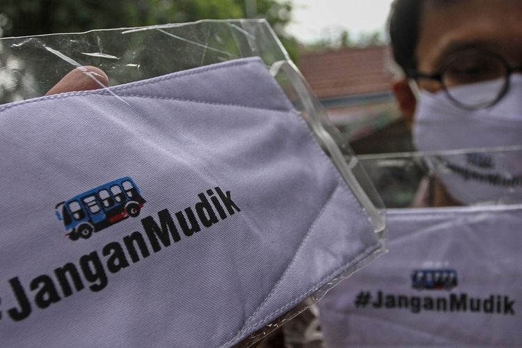 Warga menunjukkan masker kain yang didesain dengan tulisan Jangan Mudik sebelum dibagikan kepada masyarakat di Pekanbaru, Riau  (AntaraFoto)