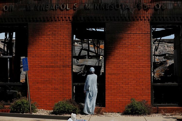 Warga lokal memeriksa kantor pos terbakar yang dihancurkan saat demonstrasi yang terus berlangsung memprotes kematian George Floyd saat ditahan oleh polisi (ANTARA FOTO)