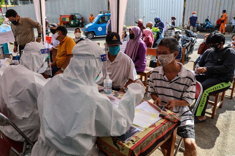 Tim medis Puskesmas Kecamatan Tanah Abang mencatat data diri warga sebelum mengambil sampel lendir saat tes usap di Pasar Bendungan Hilir, Jakarta Pusat (KOMPAS)