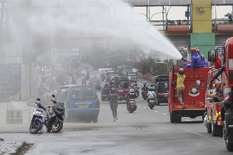 Petugas pemadam kebakaran menyemprotkan cairan disinfektan di jalan Margonda Raya, Depok, Jawa Barat, Senin (23/3/2020). Penyemprotan disinfektan di jalan protokol dan fasilitas umum di kota tersebut guna mencegah penyebaran virus corona atau COVID-19.(ANTARA FOTO