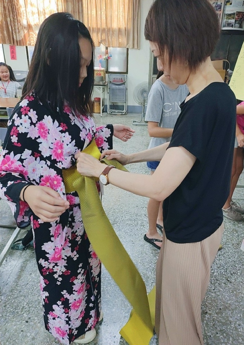 Giáo viên Cư dân mới người Nhật đem kimono cho các em học sinh mặc thử (ảnh: Cục xã hội TP.Cao Hùng