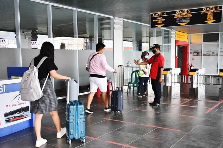 Petugas memantau penerapan Social Distancing pada antrian penumpang yang hendak memasuki gate keberangkatan di salah satu terminal penumpang yang dikelola Pelindo 1. Sumber : KOMPAS.com
