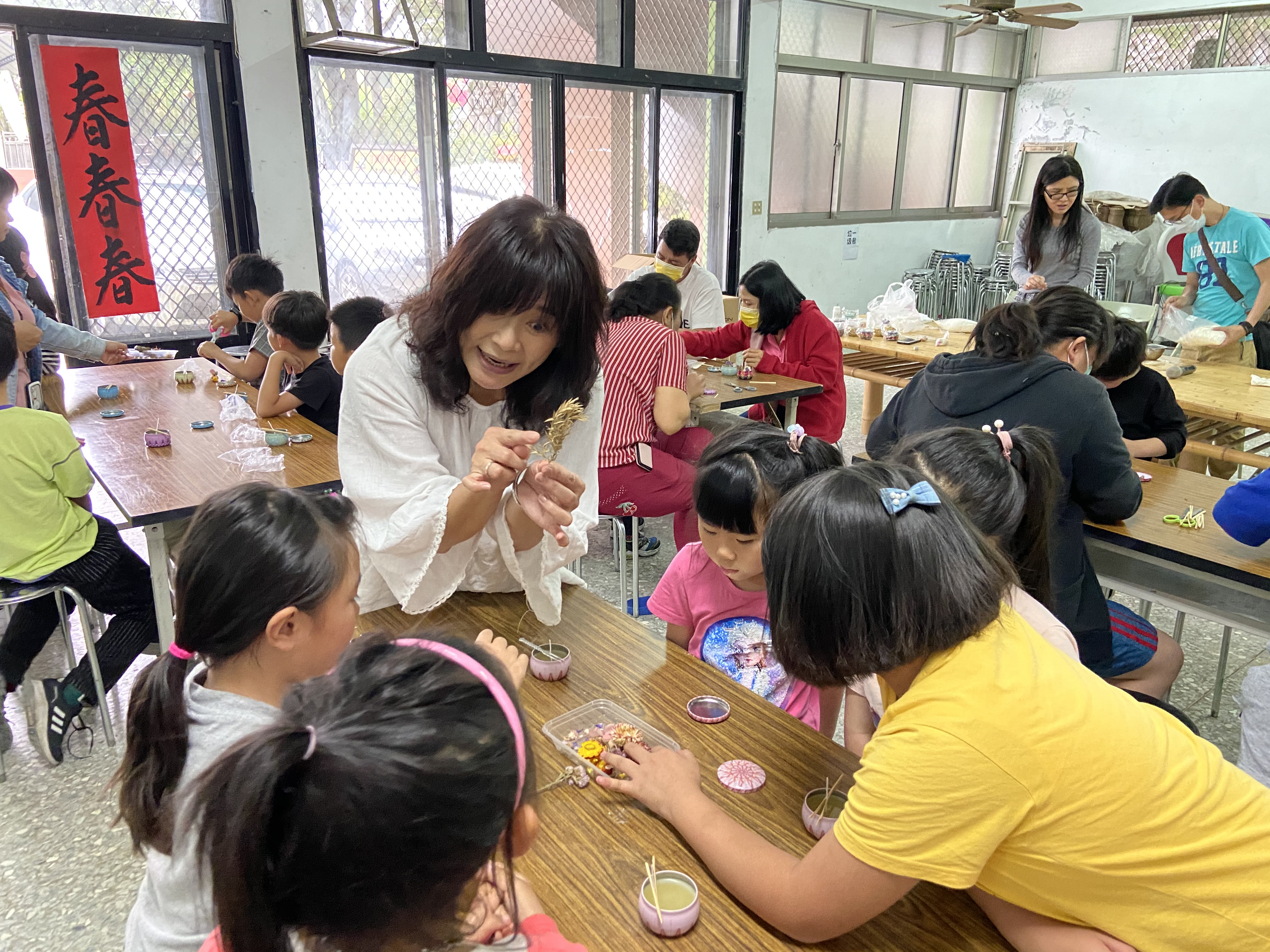 李講師詳細向新二代子女講解香氛蠟燭製作。　圖／南投縣服務站提供