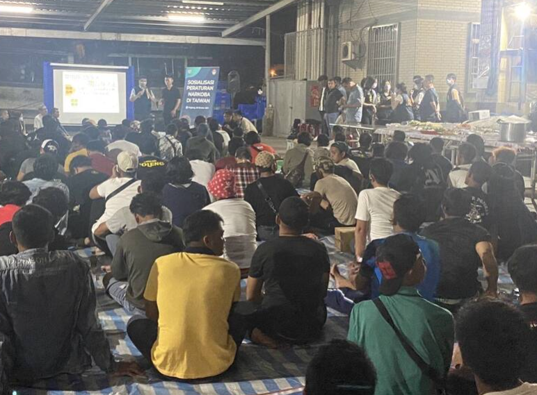 上百名的印尼籍移工，齊聚在漁獲拍賣廣場上席地而坐，聽警方宣導有關毒品的各類知識 圖／警方提供