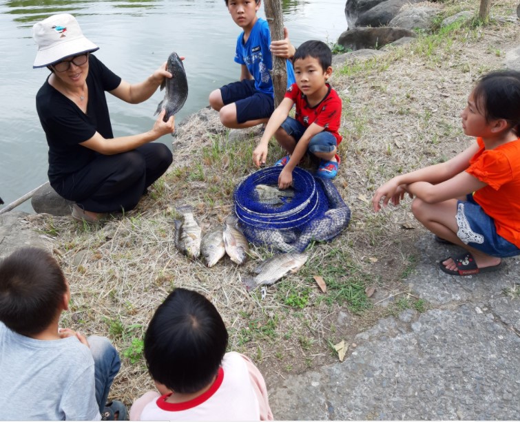 Ma Min mengajak anak-anak belajar ekologi di kolam. Sumber: Facebook Peternakan Ekologi Siloam